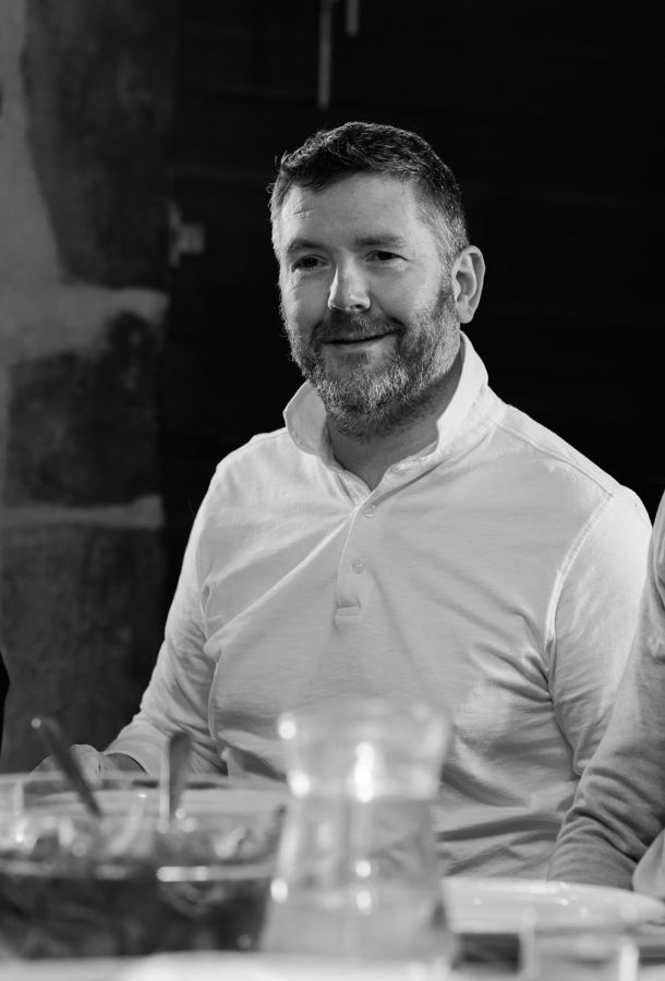 Portrait de Frédéric Angelot, en noir et blanc, souriant à table
