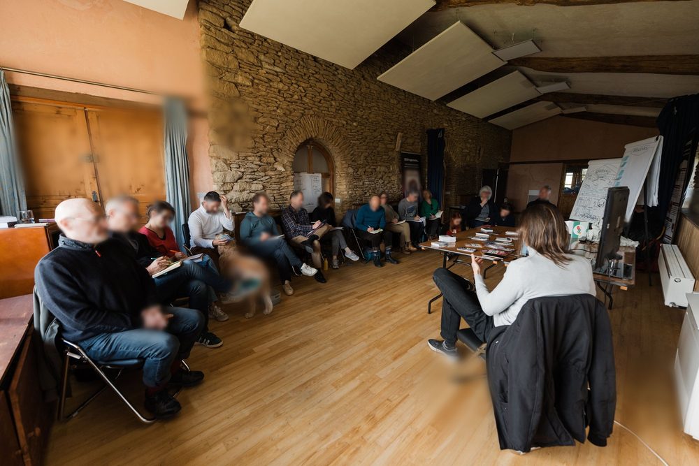 Participants assis en cercle dans la grande salle